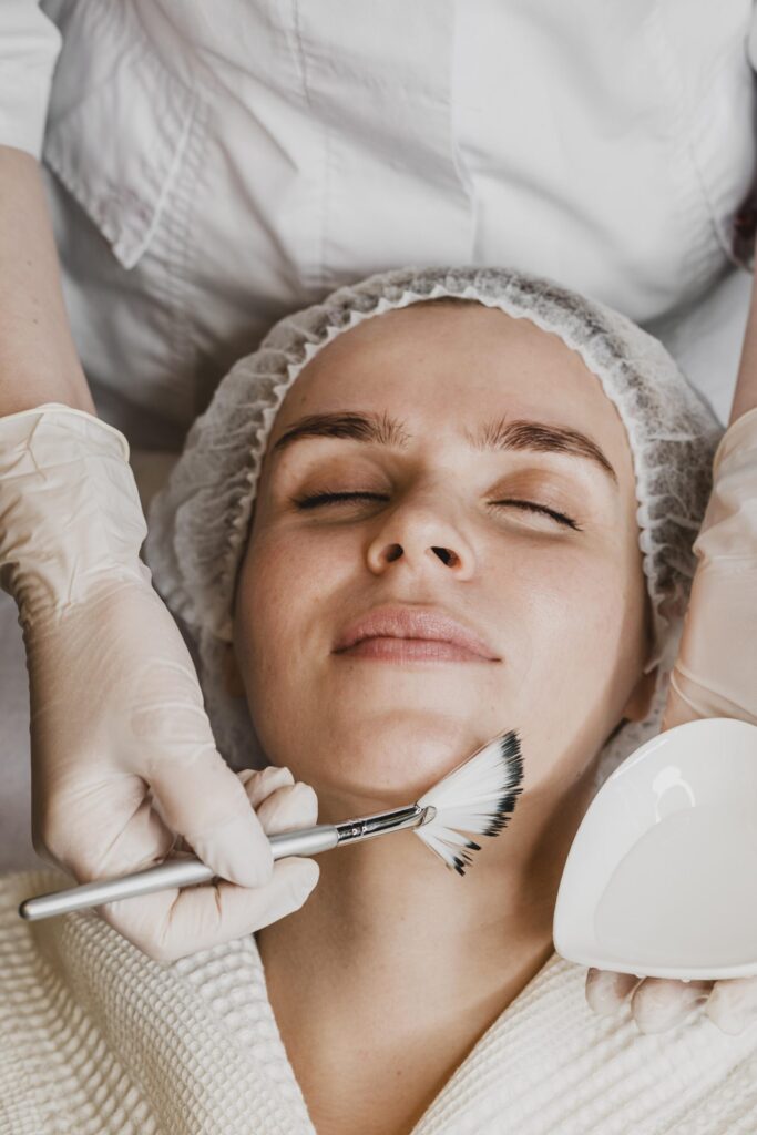 top view young beautiful woman getting face skin treatment